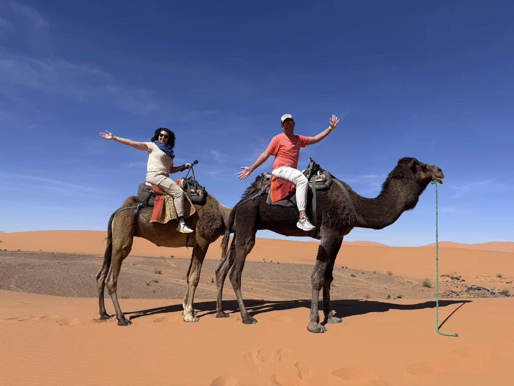Pareja montada en camellos en medio del desierto.